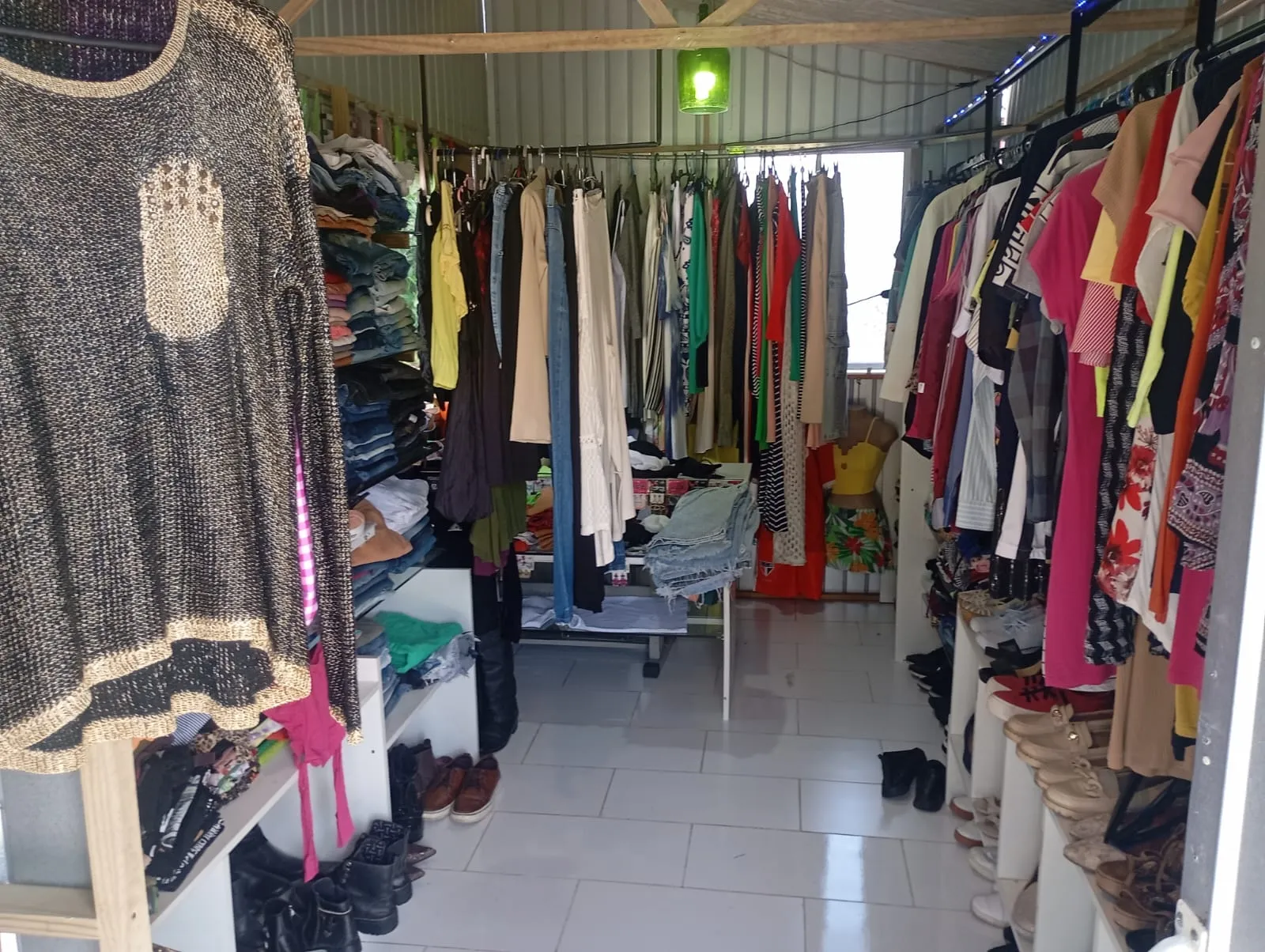 A Jujuba Mix por dentro: araras de roupas, prateleiras de jeans e calçados